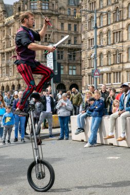 Edinburgh Festival Fringe 2022- 5 Aug-29 Aug, Edinburgh UK. events to mark its 75th anniversary. Performers  on the street. Actors of street theater and musicians in capitol of Scotland. The artist on a on one wheel bicycle.