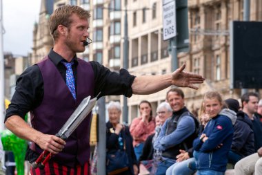 Edinburgh Festival Fringe 2022- 5 Aug-29 Aug, Edinburgh UK. events to mark its 75th anniversary. Performers  on the street. Actors of street theater and musicians in capitol of Scotland. The artist on a on one wheel bicycle.
