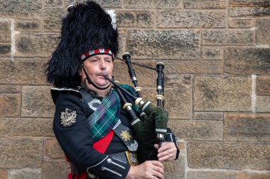 Edinburgh Festival Fringe 2022- 5 Aug-29 Aug, Edinburgh UK. Actors of street theater and musicians in capital of Scotland. A musician in traditional Scottish attire plays the bagpipes on Royal Mail