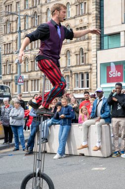 Edinburgh Festival Fringe 2022- 5 Aug-29 Aug, Edinburgh UK. events to mark its 75th anniversary. Performers  on the street. Actors of street theater and musicians in capitol of Scotland. The artist on a on one wheel bicycle.