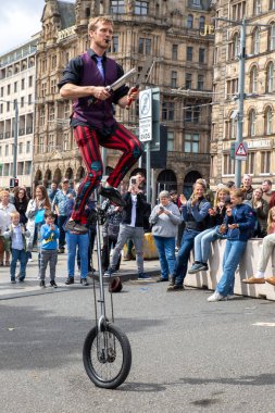 Edinburgh Festival Fringe 2022- 5 Aug-29 Aug, Edinburgh UK. events to mark its 75th anniversary. Performers  on the street. Actors of street theater and musicians in capitol of Scotland. The artist on a on one wheel bicycle.