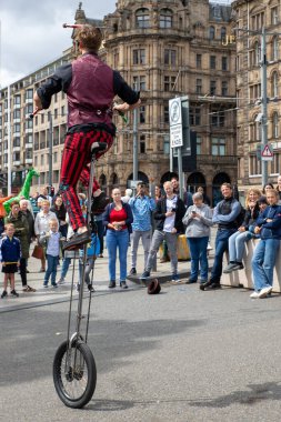 Edinburgh Festival Fringe 2022- 5 Aug-29 Aug, Edinburgh UK. events to mark its 75th anniversary. Performers  on the street. Actors of street theater and musicians in capitol of Scotland. The artist on a on one wheel bicycle.