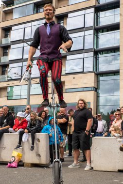 Edinburgh Festival Fringe 2022- 5 Aug-29 Aug, Edinburgh UK. events to mark its 75th anniversary. Performers  on the street. Actors of street theater and musicians in capitol of Scotland. The artist on a on one wheel bicycle.
