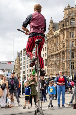Edinburgh Festival Fringe 2022- 5 Aug-29 Aug, Edinburgh UK. events to mark its 75th anniversary. Performers  on the street. Actors of street theater and musicians in capitol of Scotland. The artist on a on one wheel bicycle.