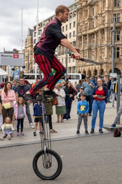 Edinburgh Festival Fringe 2022- 5 Aug-29 Aug, Edinburgh UK. events to mark its 75th anniversary. Performers  on the street. Actors of street theater and musicians in capitol of Scotland. The artist on a on one wheel bicycle.