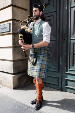 Edinburgh Festival Fringe 2022- 5 Aug-29 Aug, Edinburgh UK. Actors of street theater and musicians in capital of Scotland. A musician in traditional Scottish attire plays the bagpipes on Royal Mail
