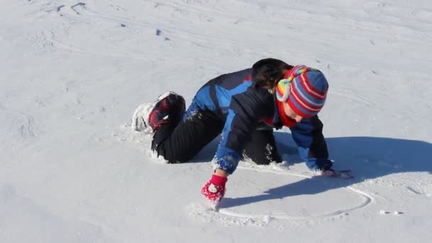 Девушка пишет на снегу — стоковое видео