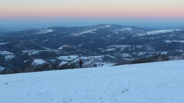 Rapaz a subir uma colina coberta de neve — Vídeo de Stock