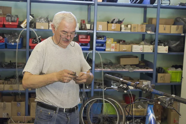 Un hombre trabaja en la reparación de bicicletas —  Fotos de Stock