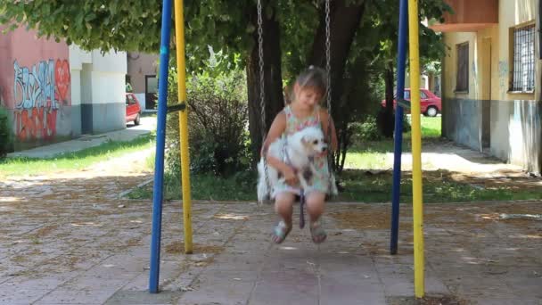 Девушка с собакой на качелях — стоковое видео
