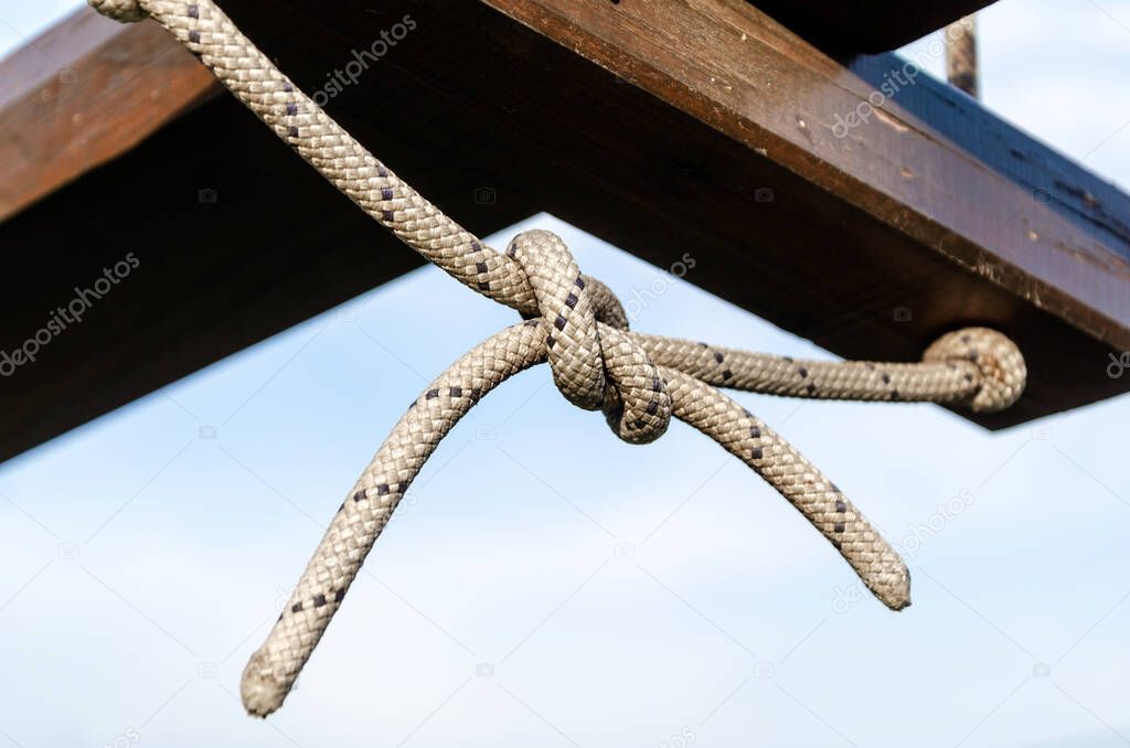 lots of ropes and a big knot against the blue sky close up