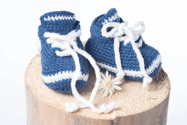 Beyaz arka planda izole edilmiş yün ayakkabılar örülmüş.