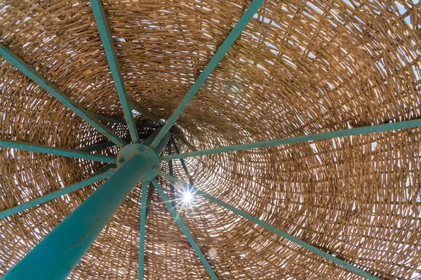 Mavi gökyüzü arkaplanındaki plaj şemsiyesi