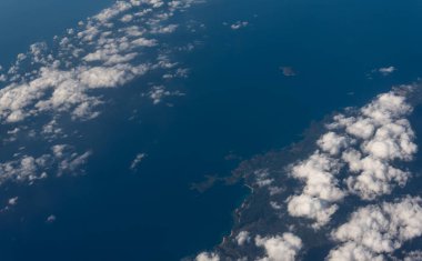 Panorama manzarası uçak penceresinden dağlara bulutlar ve mavi gökyüzüne