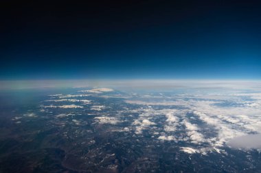 Panorama manzarası uçak penceresinden dağlara bulutlar ve mavi gökyüzüne
