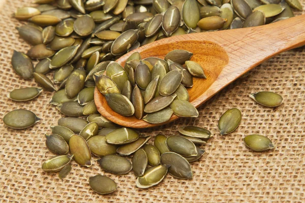 Graines de citrouille dans une cuillère en bois — Photo