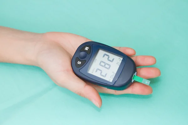 Hand met glucometer — Stockfoto