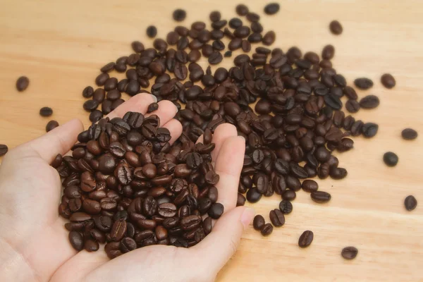 Kaffeebohnen in Händen — Stockfoto