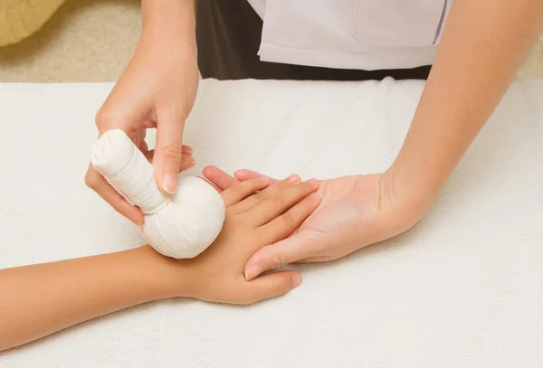 Children massage forearm with herbal compress balls — Stock Photo, Image