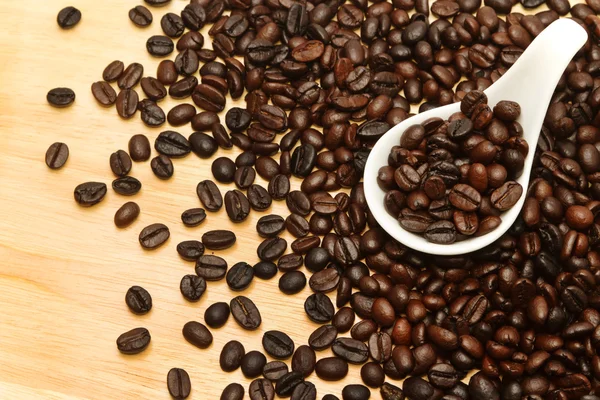 Close up de grãos de café em colher branca — Fotografia de Stock
