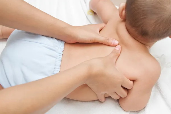 Matka ruční masáž zad svalů svého dítěte, dotek štěstí — Stock fotografie