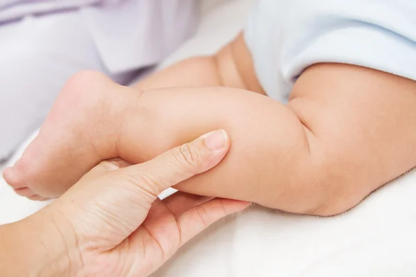 Mãe mão massagem perna de seu bebê — Fotografia de Stock