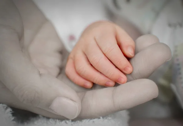 Madre sosteniendo la mano de su bebé, toque de amor — Foto de Stock