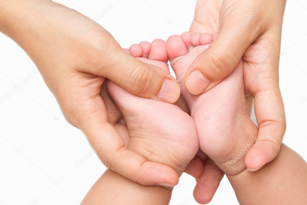 mother massaging little baby's feet