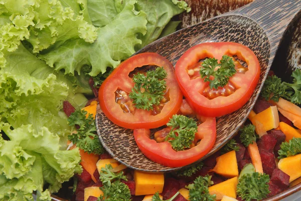 Close up tomato with parsley on the wooden spoon in slad blow — Stock Photo, Image