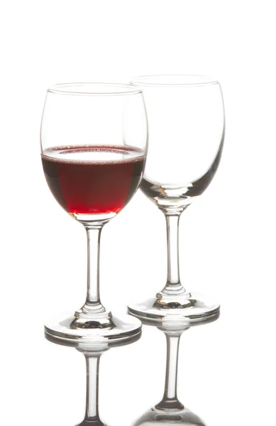 Kieliszek do wina czerwonego i pusty kieliszek do wina na białym tle — Zdjęcie stockowe