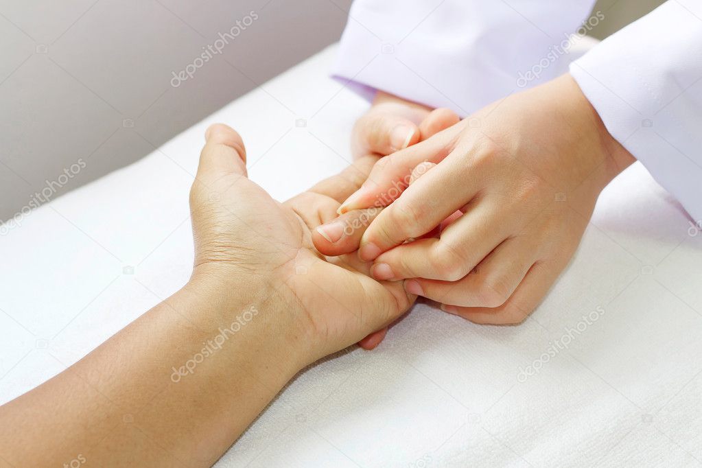 Physical therapist checks range of motion patient's hand before