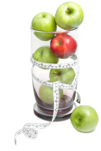 Green apple and red apple with measuring tape in glass bowl — Stock Photo, Image