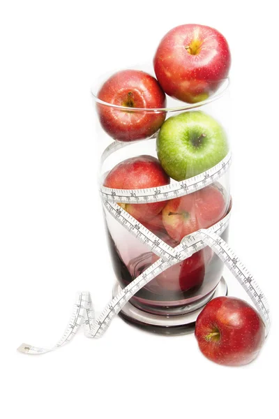 Green apple and red apple with measuring tape in glass bowl — Stock Photo, Image