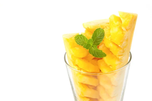 Closeup ananas segmenten in glas met muntblad op witte backg — Stockfoto