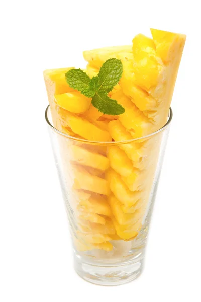 Ananas segmenten in glas met muntblad op witte achtergrond — Stockfoto