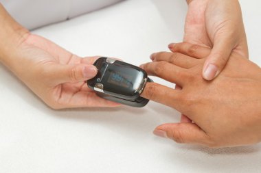 Patient with pulse oximeter on finger for monitoring clipart