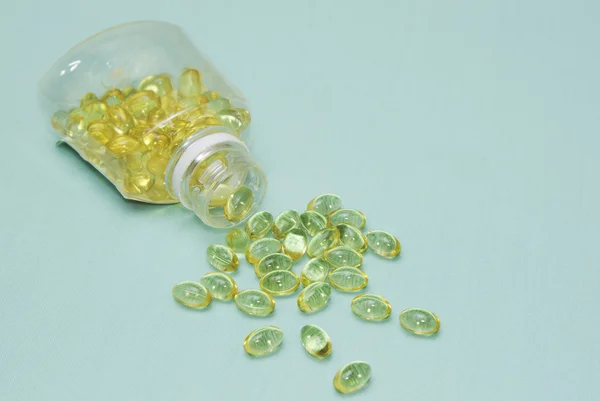 Fish oil capsule spread from bottle — Stock Photo, Image