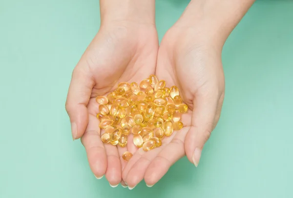 Vitamin Omega-3 fish oil capsules on a hand — Stock Photo, Image