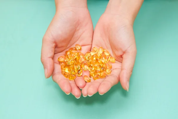 Vitamin Omega-3 fish oil capsules on a hand — Stock Photo, Image