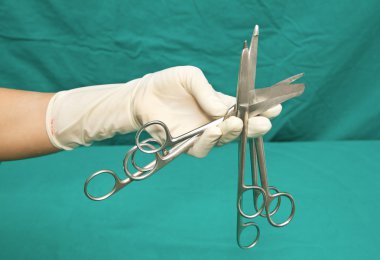 Medical scissors in hand of doctor clipart