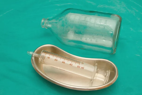 Glazen injectiespuit in steriele bekken en glazen fles voor sondevoeding dieet — Stockfoto