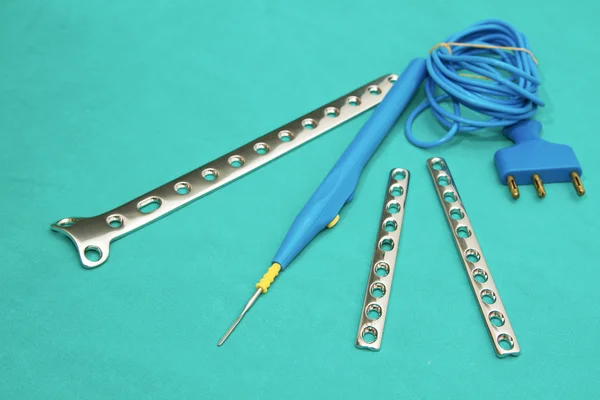 Orthopedic Implant Plates and electric cautery cord on steril — Stock Photo, Image