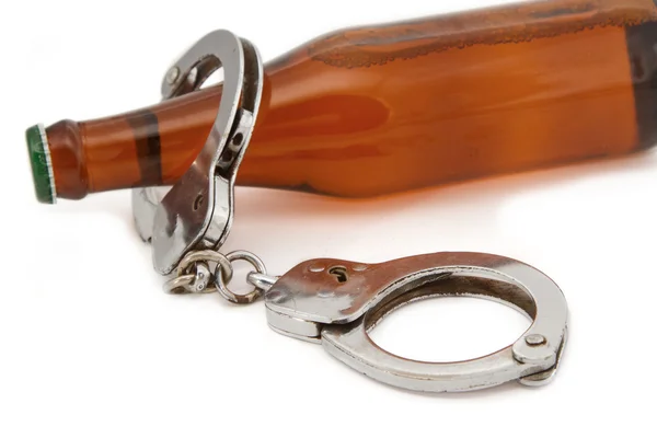 Бутылочное пиво и наручники, концепция вождения в нетрезвом виде — стоковое фото