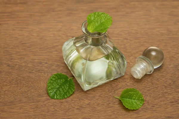 Essential aroma peppermint oil and fresh mint on wooden backgr — Stock Photo, Image