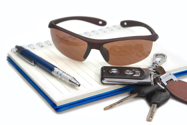 Солнцезащитные очки и ключи от машины на книге, концепция путешествия через дверь — стоковое фото
