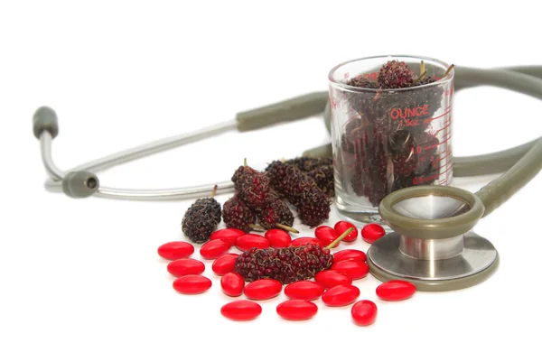 Pilules vitaminées et mûrier frais avec stéthoscope — Photo