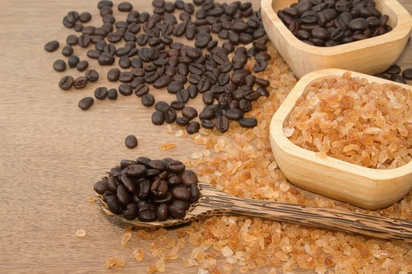 Grano de café en la cuchara de madera y azúcar dulce de roca —  Fotos de Stock