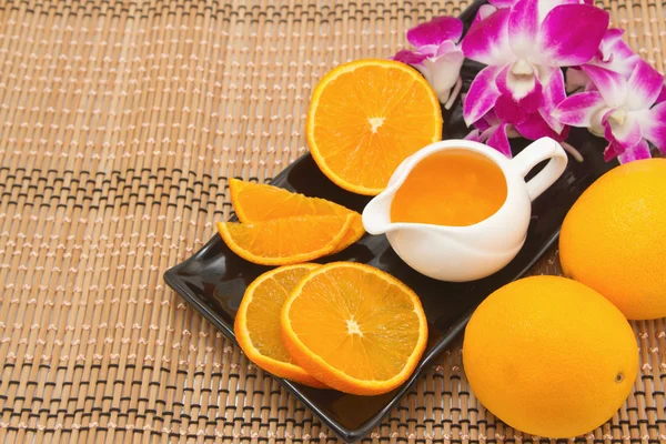 Апельсиновый сок и свежие фрукты на деревянном столе — стоковое фото