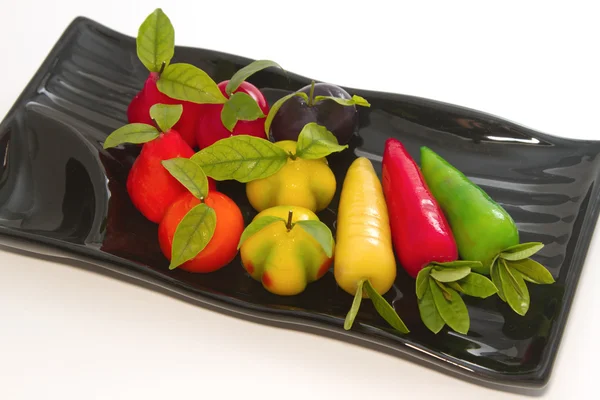 Deletable imitation fruits in black plate — Stock Photo, Image