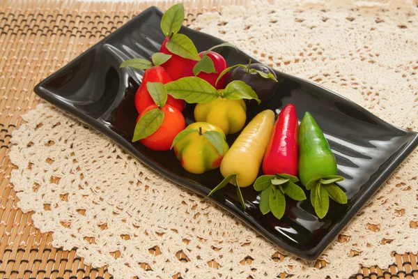 Deletable imitation fruits in black plate — Stock Photo, Image